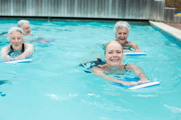 Mulheres com kickboard nadando na piscina — Fotografia de Stock