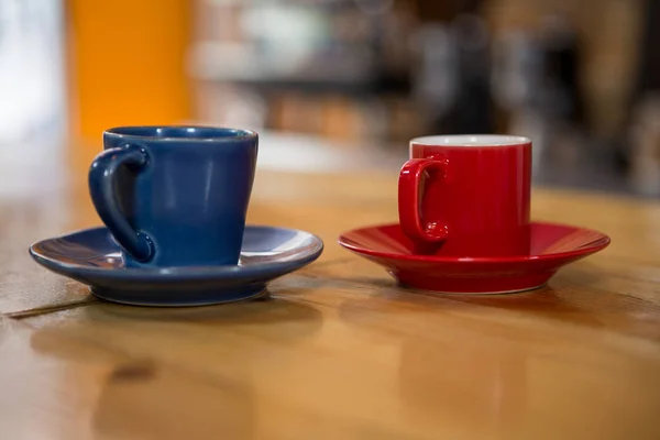 Filiżanki do kawy na drewnianym stole w kafeterii — Zdjęcie stockowe