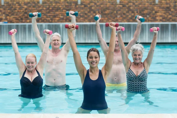 Instrutora feminina com nadadores seniores exercitando — Fotografia de Stock