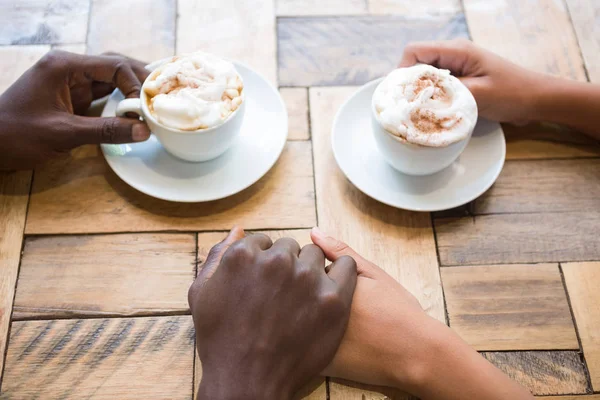 Casal tomando café enquanto segurando as mãos — Fotografia de Stock