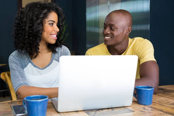 Couple looking at each other with laptop — Stock Photo, Image