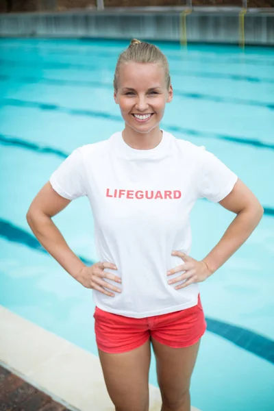 Salvavidas mujer de confianza de pie junto a la piscina —  Fotos de Stock
