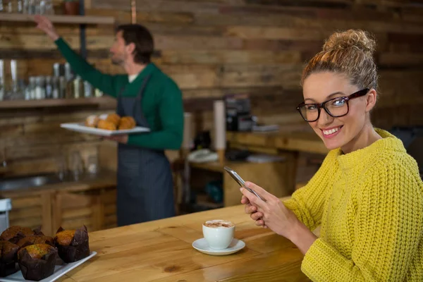 Woman using mobile phone in coffee shop — Stock Photo, Image