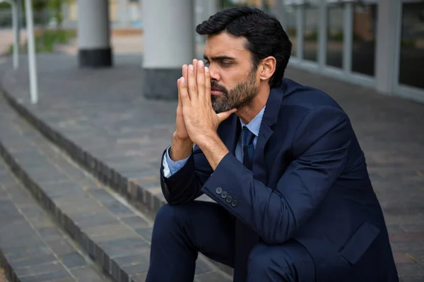 Стрессовый бизнесмен сидит на ступеньках — стоковое фото