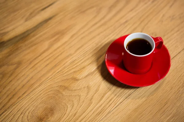 Red cup and saucer on table in cafeteria — Stock Photo, Image