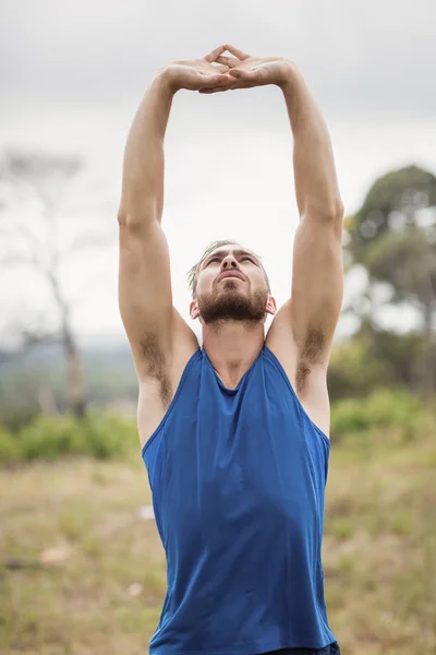 Fit man utför stretching övning — Stockfoto