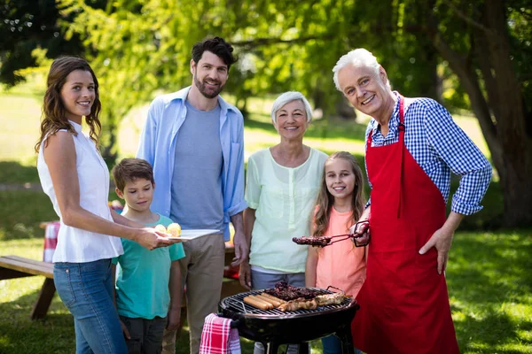 Семья из нескольких поколений стоит рядом с барбекю — стоковое фото