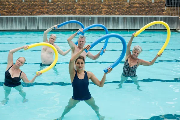 Trainer and senior swimmers exercising — Stock Photo, Image