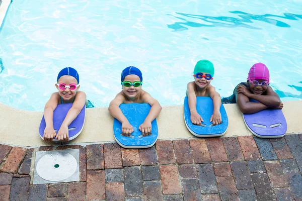 Pequeños nadadores con tablas de kickboard junto a la piscina — Foto de Stock