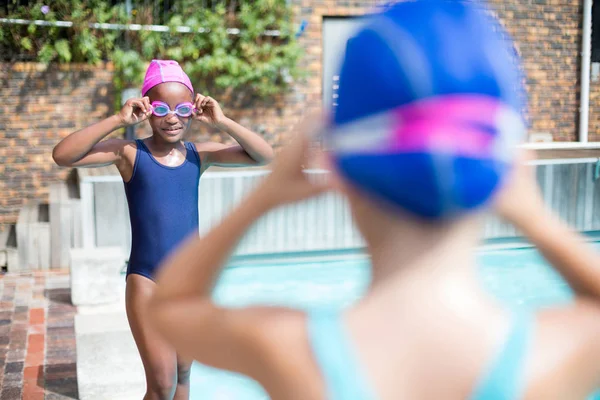 Ragazze che indossano occhiali da nuoto a bordo piscina — Foto Stock