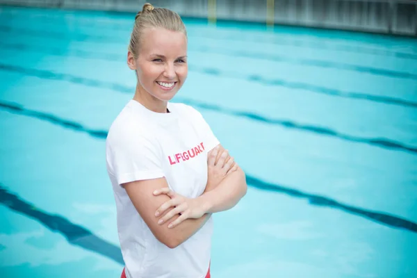 Female lifeguard standing at poolside — Stock Photo, Image