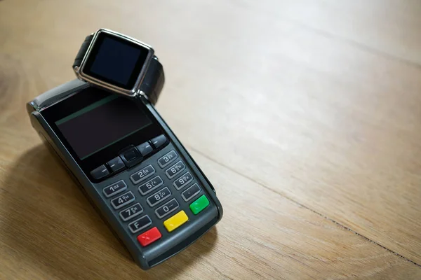Reloj inteligente y lector de tarjetas de crédito en la mesa — Foto de Stock