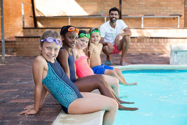 Istruttore maschio e bambini rilassanti a bordo piscina — Foto Stock