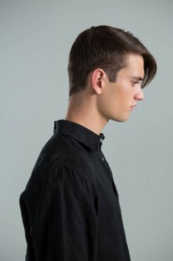 Androgynous man in black shirt looking sideways  clipart