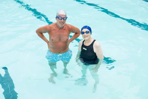 Senior paar staande in zwembad — Stockfoto