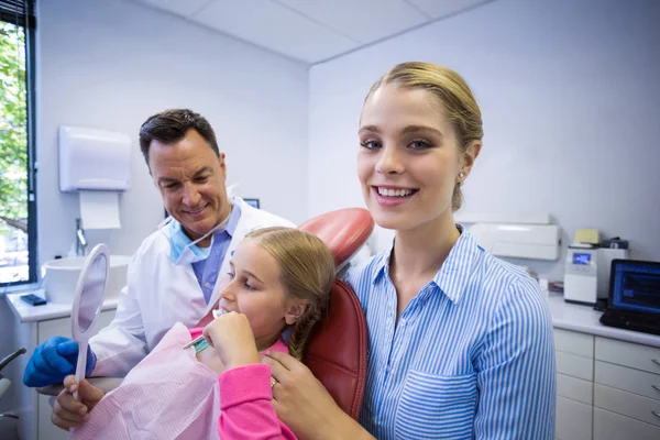 Dentista que asiste al paciente mientras se cepilla los dientes — Foto de Stock