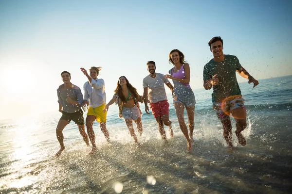 Amigos corriendo en la orilla en la playa —  Fotos de Stock