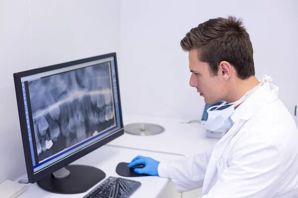 Dentista examinando informe de rayos X en el ordenador —  Fotos de Stock