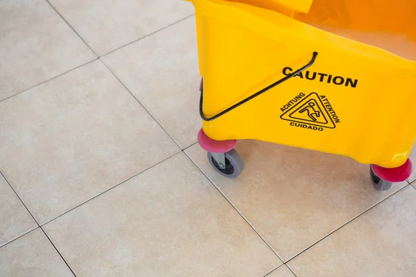 High angle view of sign on mop bucket — Stock Photo, Image
