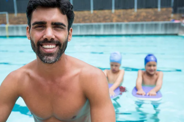 Allenatore sorridente seduto vicino alla piscina — Foto Stock