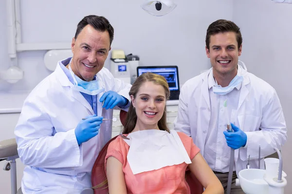 Gülümseyen diş hekimleri ve Bayan hasta — Stok fotoğraf