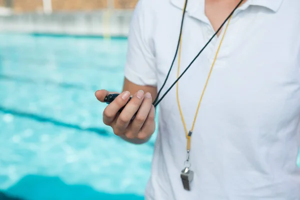 Entrenadora sosteniendo cronómetro en la piscina —  Fotos de Stock