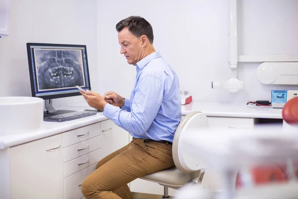 Glad tandläkare använder mobiltelefon — Stockfoto
