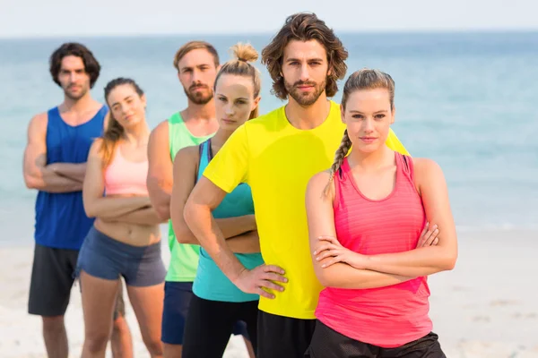 Vänner i sportkläder på stranden — Stockfoto