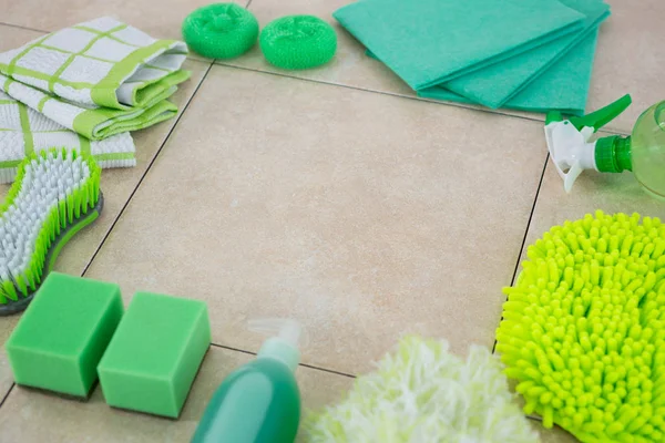Groene reinigingsproducten gerangschikt op tegelvloer — Stockfoto