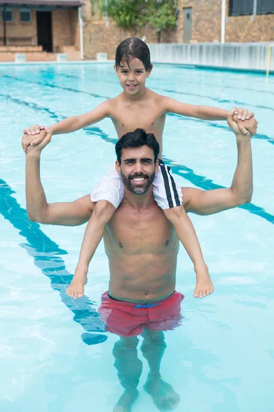 Ojciec syna noszenia na ramieniu w basenie — Zdjęcie stockowe