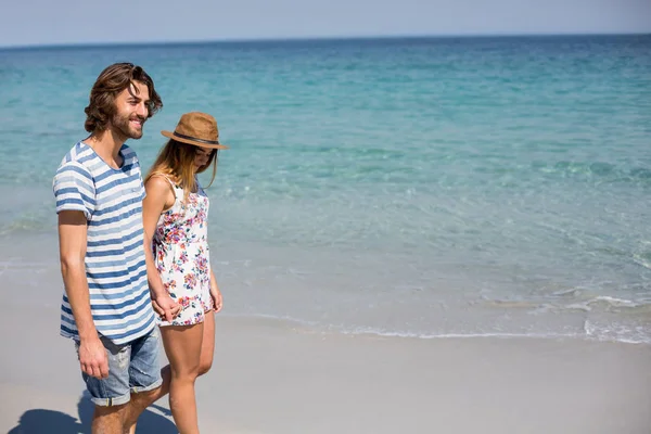 Casal andando na praia durante o dia ensolarado — Fotografia de Stock
