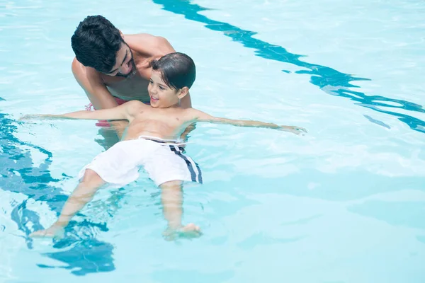 Padre e hijo jugando en la piscina — Foto de Stock