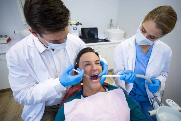 Dentistas que dan anestesia al paciente masculino —  Fotos de Stock
