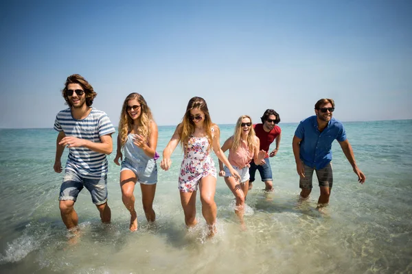 Felices amigos corriendo en el mar —  Fotos de Stock