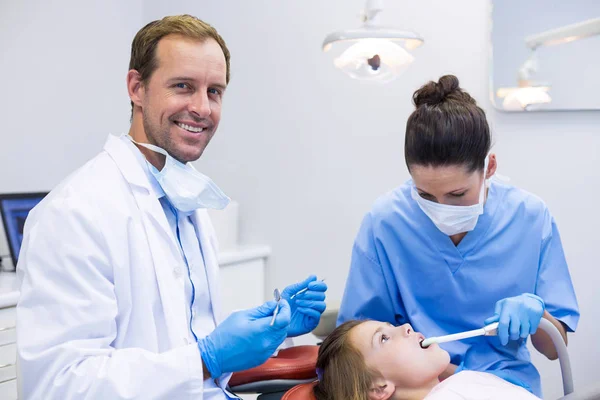 Dentista examinando um paciente jovem com ferramentas — Fotografia de Stock