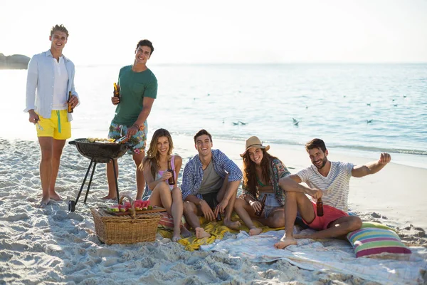 Vrienden met dranken barbecue op strand — Stockfoto