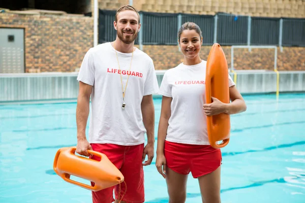 Two lifeguards standing with rescue buoy — Stock Photo, Image