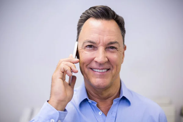 Cep telefonu üzerinde konuşurken diş hekimi — Stok fotoğraf
