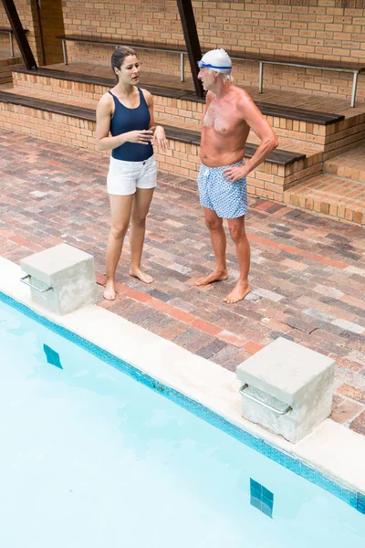 Entraîneur de natation interagissant avec un homme âgé — Photo