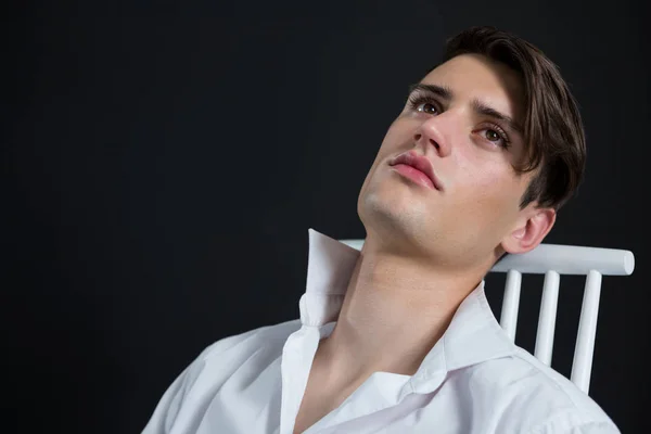 Homme androgyne posant assis sur une chaise — Photo