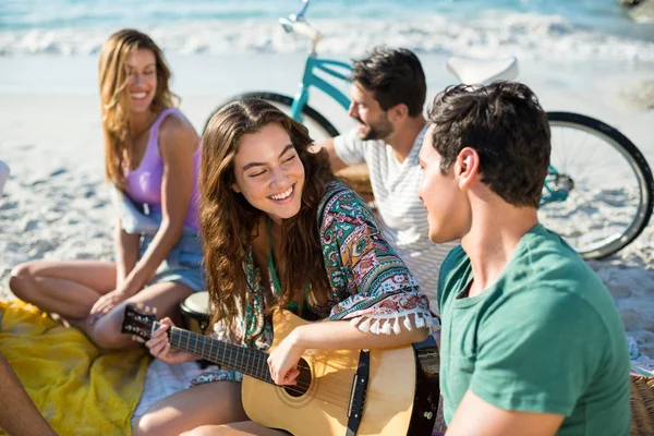 Freunde genießen, während sie am Strand sitzen — Stockfoto