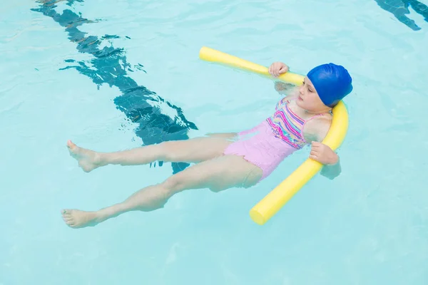 Jente som svømmer i bassenget – stockfoto