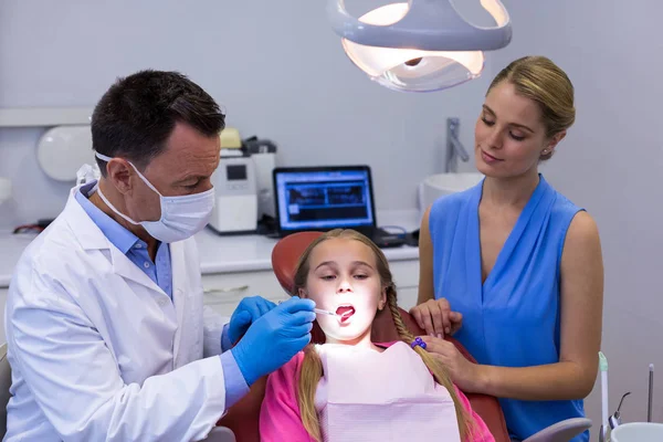 Dentista examinando paciente joven con herramientas — Foto de Stock