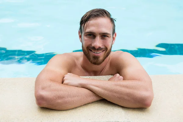 Smiling lifeguard leaning on poolside — Stock Photo, Image