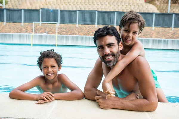 Vader en kinderen glimlachend in het zwembad — Stockfoto