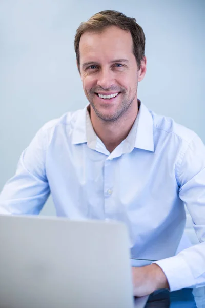 Dentista sorrindo trabalhando no laptop — Fotografia de Stock