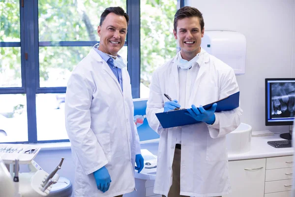 Щасливі стоматологи, що стоять з файлом — стокове фото
