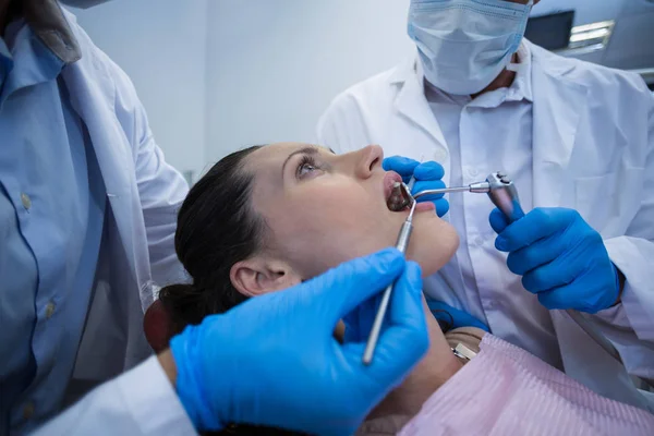 Zahnärzte untersuchen Patientin mit Werkzeug — Stockfoto