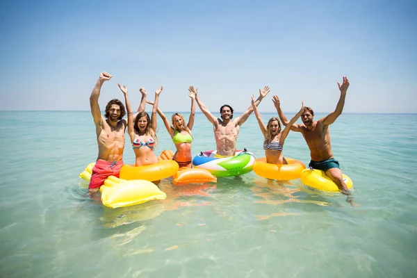 Amigos desfrutando em anéis infláveis e jangadas de piscina — Fotografia de Stock