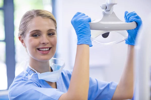 Женщина-медсестра регулирует свет зубов — стоковое фото